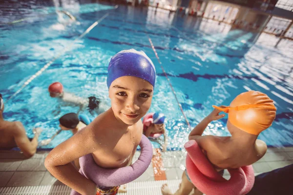 Boldog gyermekek gyerekek csoport úszástanulás medence osztály — Stock Fotó