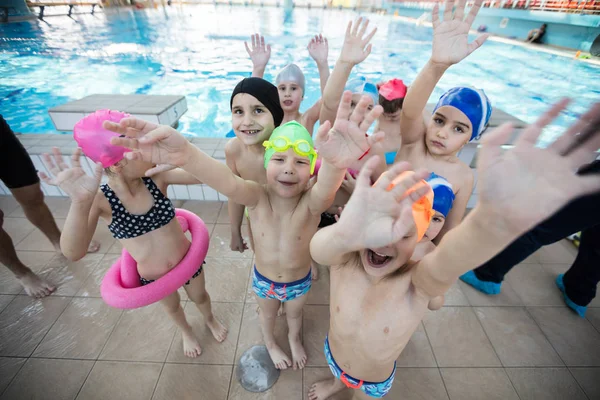 Glückliche Kindergruppe im Schwimmbad lernt schwimmen — Stockfoto