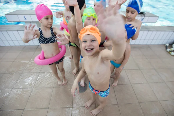 Glada barn barn gruppen vid poolen klass att lära sig att simma — Stockfoto