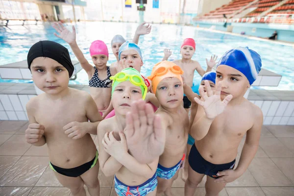 Niños felices grupo de niños en la clase de piscina aprender a nadar —  Fotos de Stock