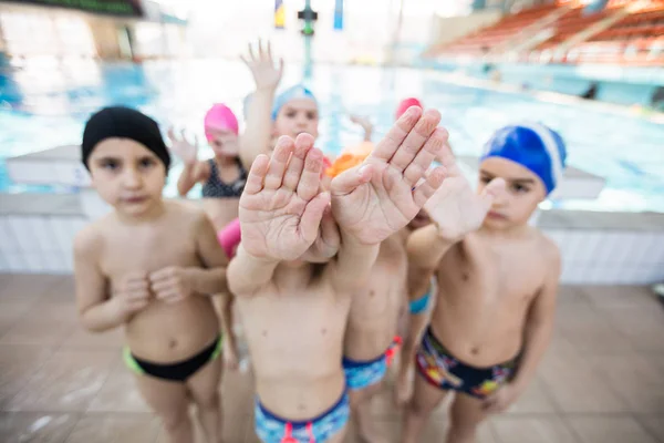 Glada barn barn gruppen vid poolen klass att lära sig att simma — Stockfoto