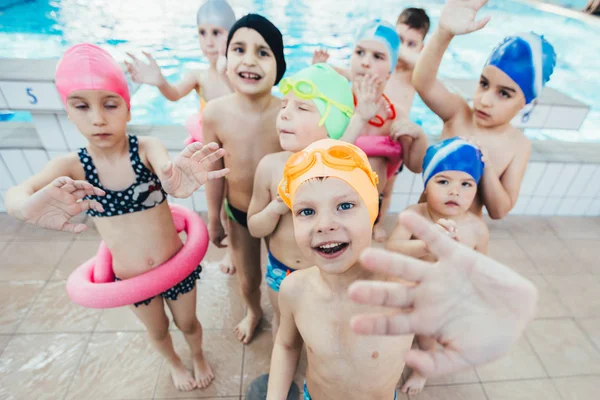 Glada barn barn gruppen vid poolen klass att lära sig att simma — Stockfoto