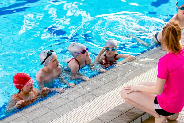 Crianças felizes grupo de crianças na aula de piscina aprender a nadar — Fotografia de Stock