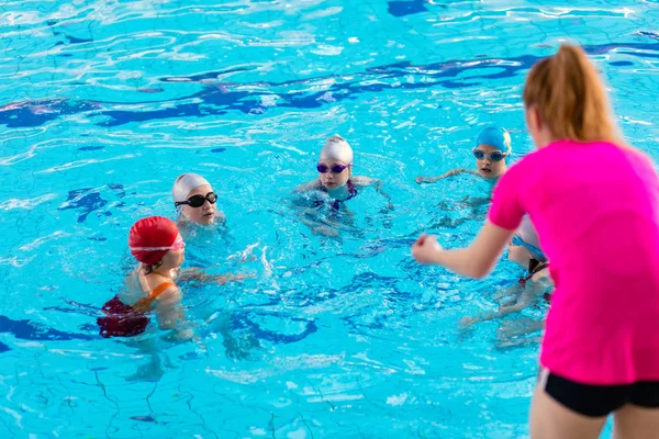 De gelukkige kinderen kids groep op zwembad klasse leren om te zwemmen — Stockfoto