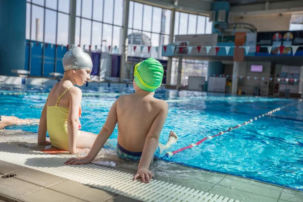 Glückliche Kindergruppe im Schwimmbad lernt schwimmen — Stockfoto