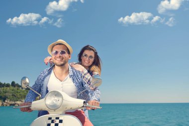 Aşk ve zevk sahip eğlenceli bir scooter üzerinde güzel doğada sürme güzel genç Çift