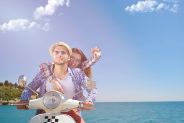 Aşk ve zevk sahip eğlenceli bir scooter üzerinde güzel doğada sürme güzel genç Çift