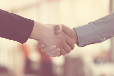 İş yerindeki insanlar: bir toplantıda erkek ve kadın el sıkışır.