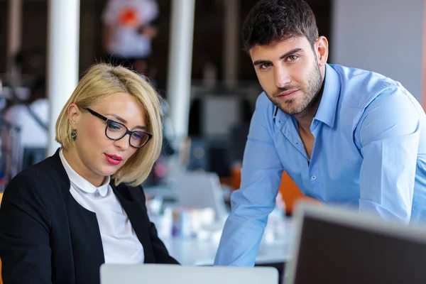 Onorevoli colleghi in chat, seduti insieme al tavolo dell'ufficio, sorridenti — Foto Stock