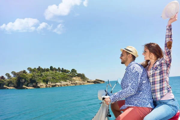 Hermosa pareja joven enamorada disfrutando y divirtiéndose montando en una scooter en una hermosa naturaleza — Foto de Stock