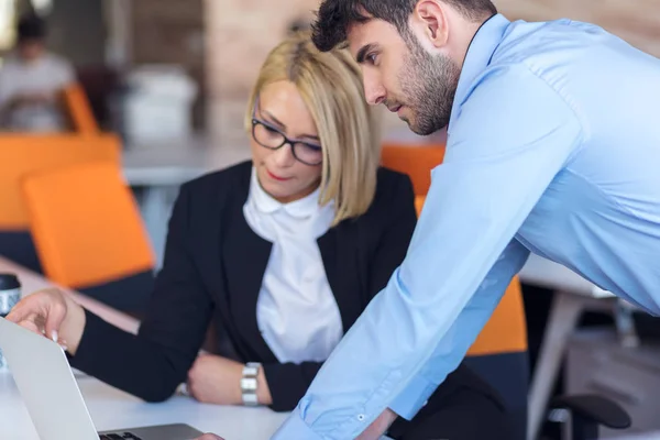 Onorevoli colleghi in chat, seduti insieme al tavolo dell'ufficio, sorridenti — Foto Stock