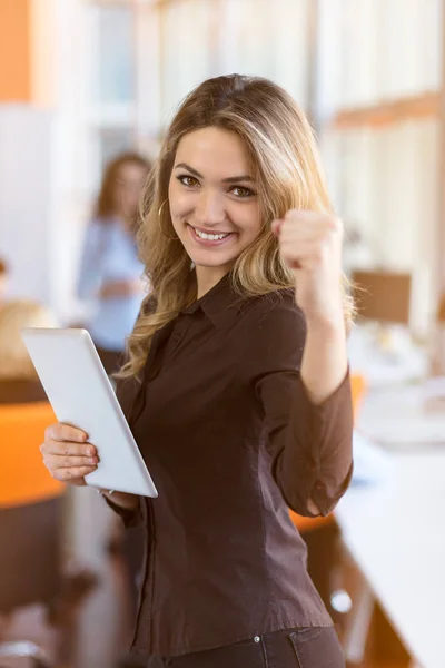 portrait of young business woman at modern startup office interior, team in meeting in background