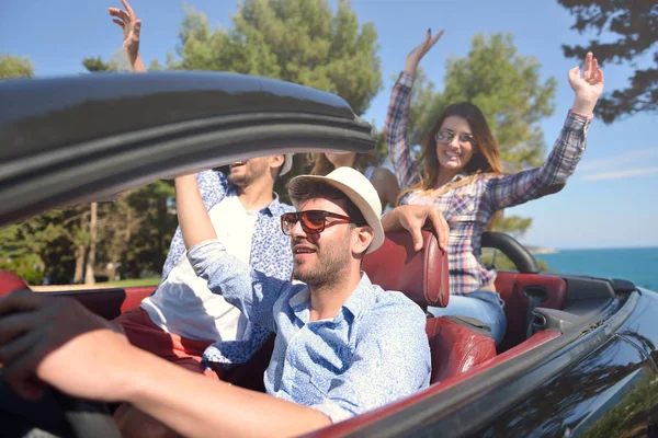 Ocio, viaje por carretera, viajes y concepto de personas - amigos felices conduciendo en coche cabriolet a lo largo de la carretera del país — Foto de Stock