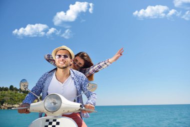Aşk ve zevk sahip eğlenceli bir scooter üzerinde güzel doğada sürme güzel genç Çift