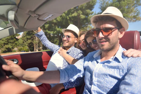 Wypoczynek, podróż, Podróże i ludzi pojęcie - szczęśliwy przyjaciół jazdy w samochodzie cabriolet wzdłuż drogi kraj — Zdjęcie stockowe