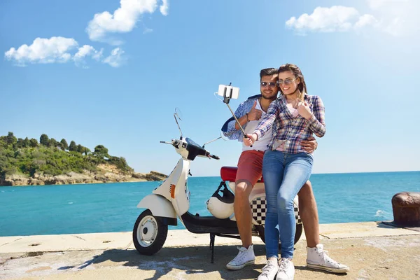 Landkarte gemeinsam untersuchen. Schönes junges Liebespaar sitzt zusammen auf Roller und untersucht Landkarte — Stockfoto