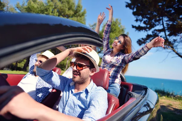 Ocio, viaje por carretera, viajes y concepto de personas - amigos felices conduciendo en coche cabriolet a lo largo de la carretera del país — Foto de Stock