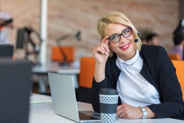 Müşteri hizmetleri temsilcisi iş başında. Bilgisayar çalışma kulaklık güzel genç kadın