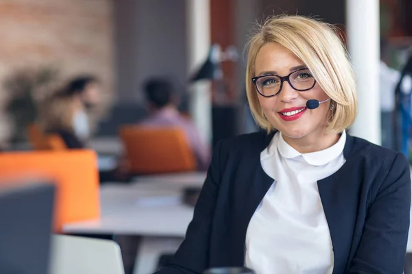 Customer service representative at work. Beautiful young woman in headset working at the computer