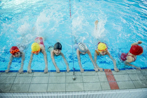 Instrutor e grupo de crianças fazendo exercícios perto de uma piscina — Fotografia de Stock