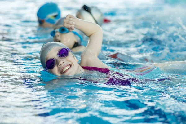 Glückliche Kindergruppe im Schwimmbad lernt schwimmen — Stockfoto