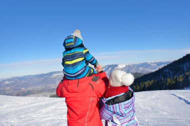 Baba, anne ve çocuk eğleniyor ve karlı kış yürüyüş doğada oynamaya.