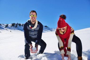 Kaygısız mutlu genç çift karda birlikte eğleniyor.