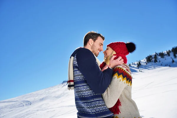 Casal amoroso abraçando no parque de inverno. Puseram bonés e cachecóis coloridos. . — Fotografia de Stock