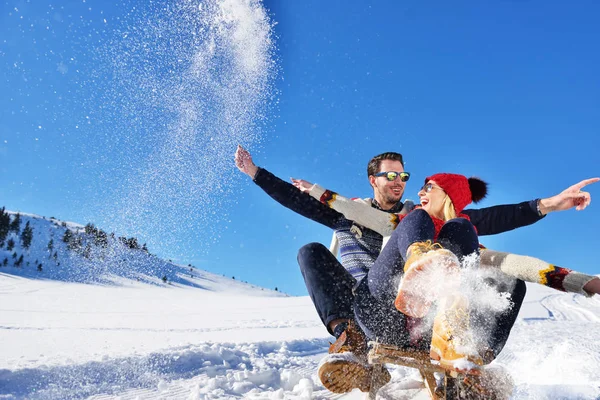 Kızak ve güneşli kış gününde zevk genç Çift — Stok fotoğraf