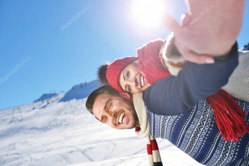 Loving couple playing together in snow outdoor.