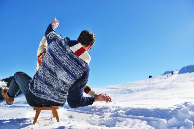Kızak ve güneşli kış gününde zevk genç Çift