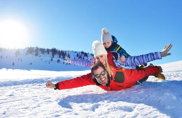 güzel güneşli kış günü doğada açık taze karda oynarken mutlu genç aile