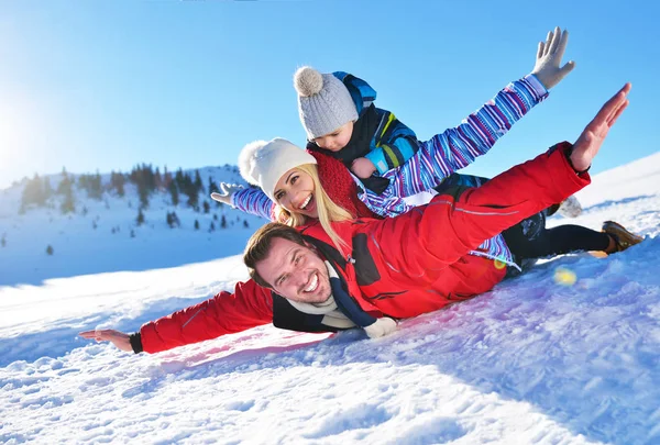 Boldog fiatal család játszik a friss hóban gyönyörű napsütéses téli nap, kültéri, természet — Stock Fotó
