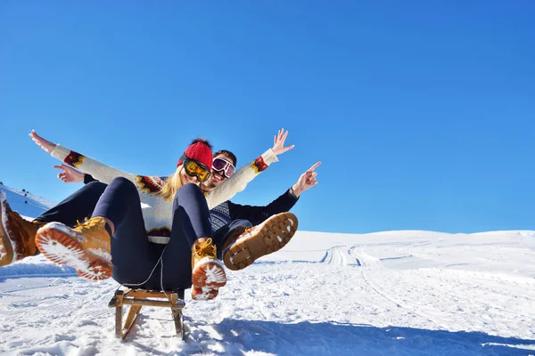 Kızak ve güneşli kış gününde zevk genç Çift