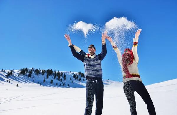 Kaygısız mutlu genç çift karda birlikte eğleniyor.
