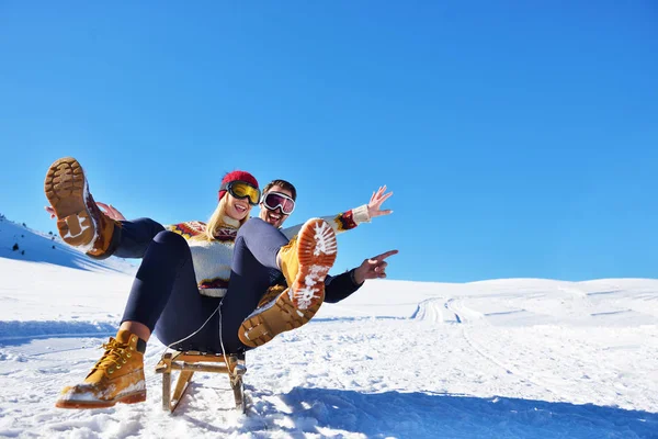 Νεαρό ζευγάρι με έλκηθρο και να απολαμβάνουν την ηλιόλουστη μέρα του χειμώνα — Φωτογραφία Αρχείου