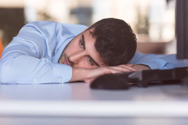 Retrato de um trabalhador de escritório deprimido deitado em sua mesa e pensando — Fotografia de Stock