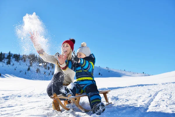 Feliz familia joven jugando en nieve fresca en hermoso día de invierno soleado al aire libre en la naturaleza —  Fotos de Stock