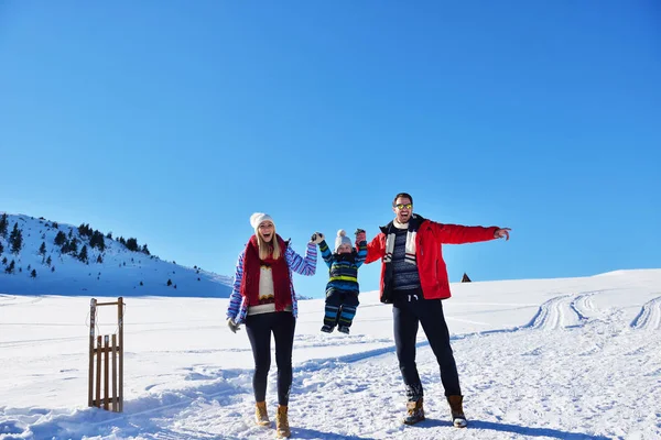 güzel güneşli kış günü doğada açık taze karda oynarken mutlu genç aile