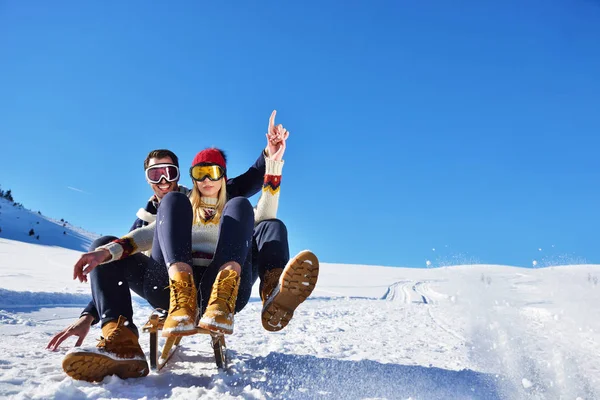 Kızak ve güneşli kış gününde zevk genç Çift