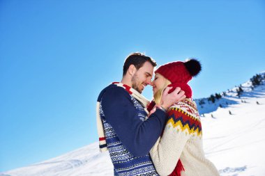 Sevgi dolu iki kış parkta kucaklayan. Renkli kapaklar ve eşarp koydular.