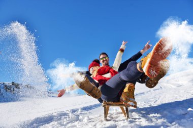 Kızak ve güneşli kış gününde zevk genç Çift