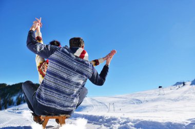 Kızak ve güneşli kış gününde zevk genç Çift