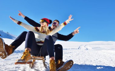 Kızak ve güneşli kış gününde zevk genç Çift