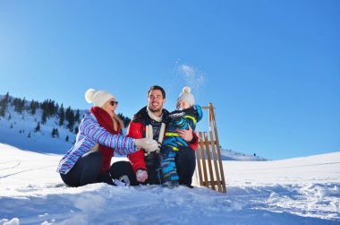 güzel güneşli kış günü doğada açık taze karda oynarken mutlu genç aile