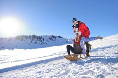 Kızak ve güneşli kış gününde zevk genç Çift