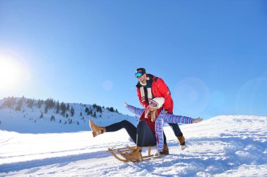 Kızak ve güneşli kış gününde zevk genç Çift