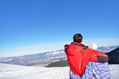 kar dağ görünümlü kürk başlık ceketler, sevgi dolu bir çift arka görünüm