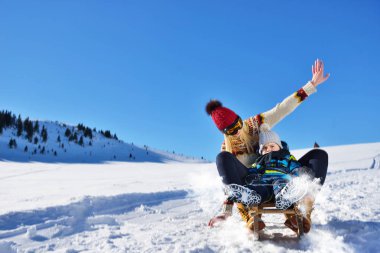 Kızak ve güneşli kış gününde zevk genç Çift