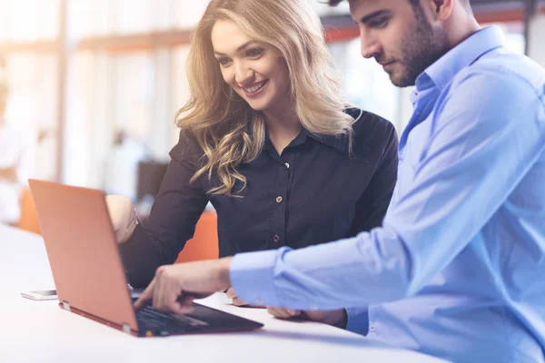 Una giovane coppia che lavora insieme su un portatile in ufficio. Concetti di lavoro di squadra . — Foto Stock